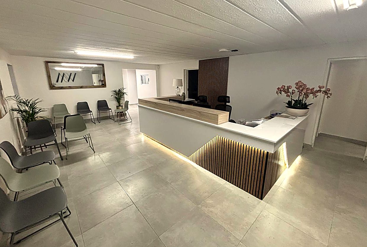 Seating beside the WillowMed reception desk, with warm oak slat detailing